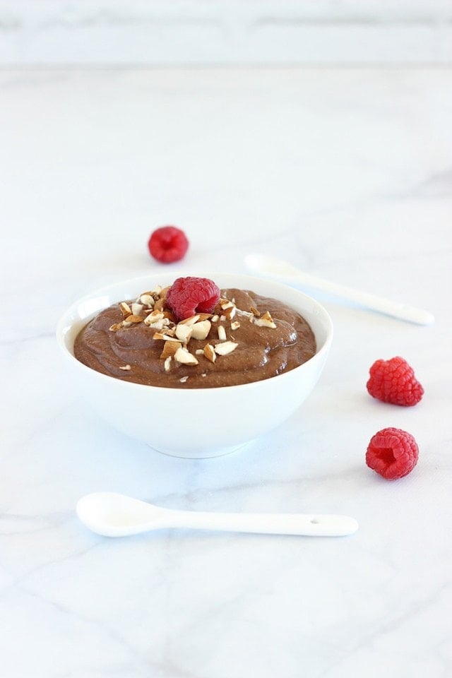 mocha teff pudding in a bowl with raspberries