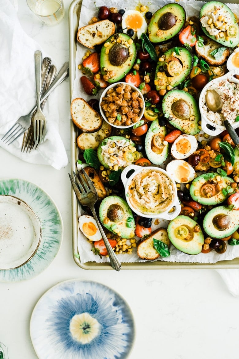 Sheet pan full of avocados, chickpeas, dips and bread