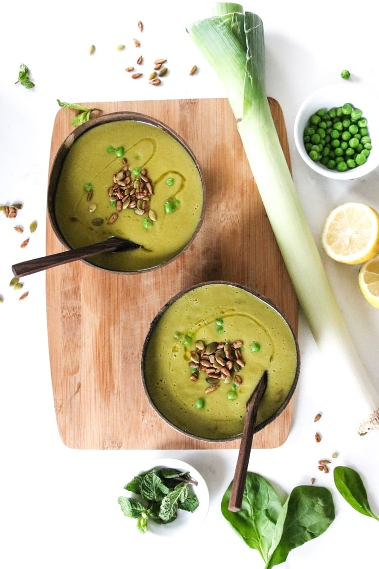 two bowls of green pea soup with sprinkle of seeds