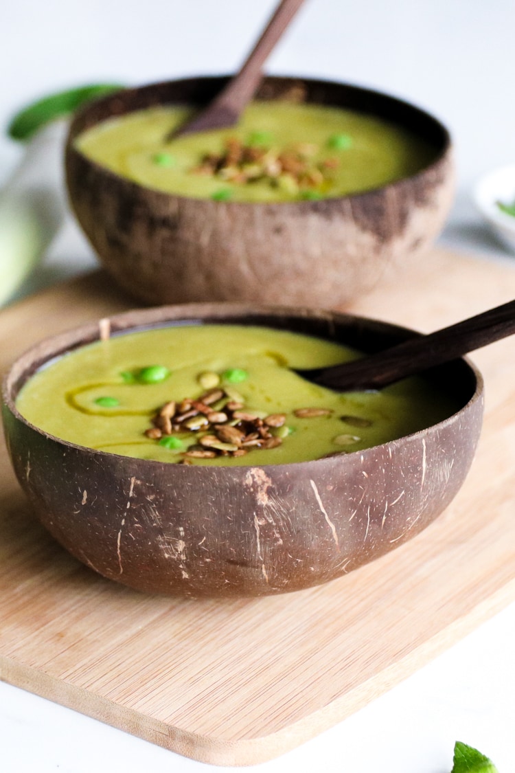 two bowls of green pea soup with sprinkle of seeds