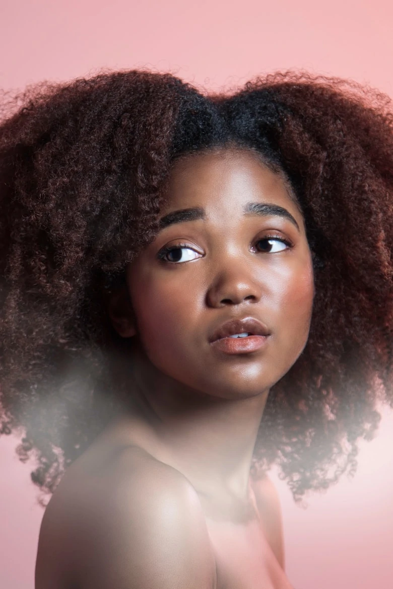 portrait shot of a girl with curly black hair and flawless skin