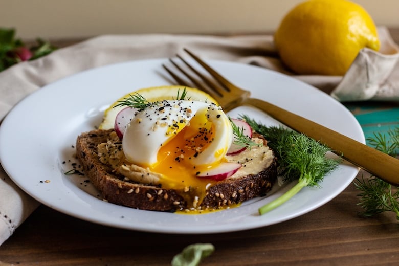 plate with egg on toast with hummus spread