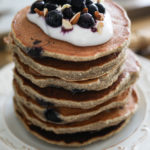 a stack of easy and healthy pancakes in a tray topped with yogurt and blueberries