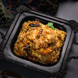 tray of south asian fish biryani with a cinnamon stick on top