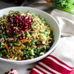bowl of easy salad recipe with colourful vegetables and topped with pomegranate and seeds surrounded by vegetables