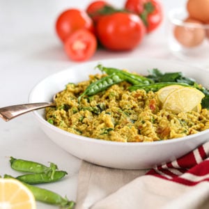 bowl of egg oatmeal breakfast topped with mange tout and lemon slices