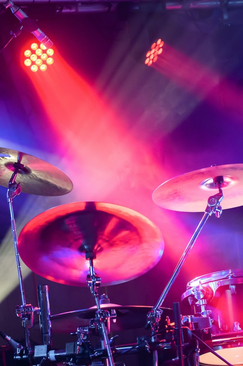 drum kit and cymbals under stage spotlights