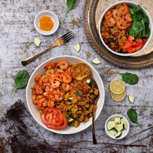 Bowl of vegetable quinoa with garlic shrimp recipe flat-lay