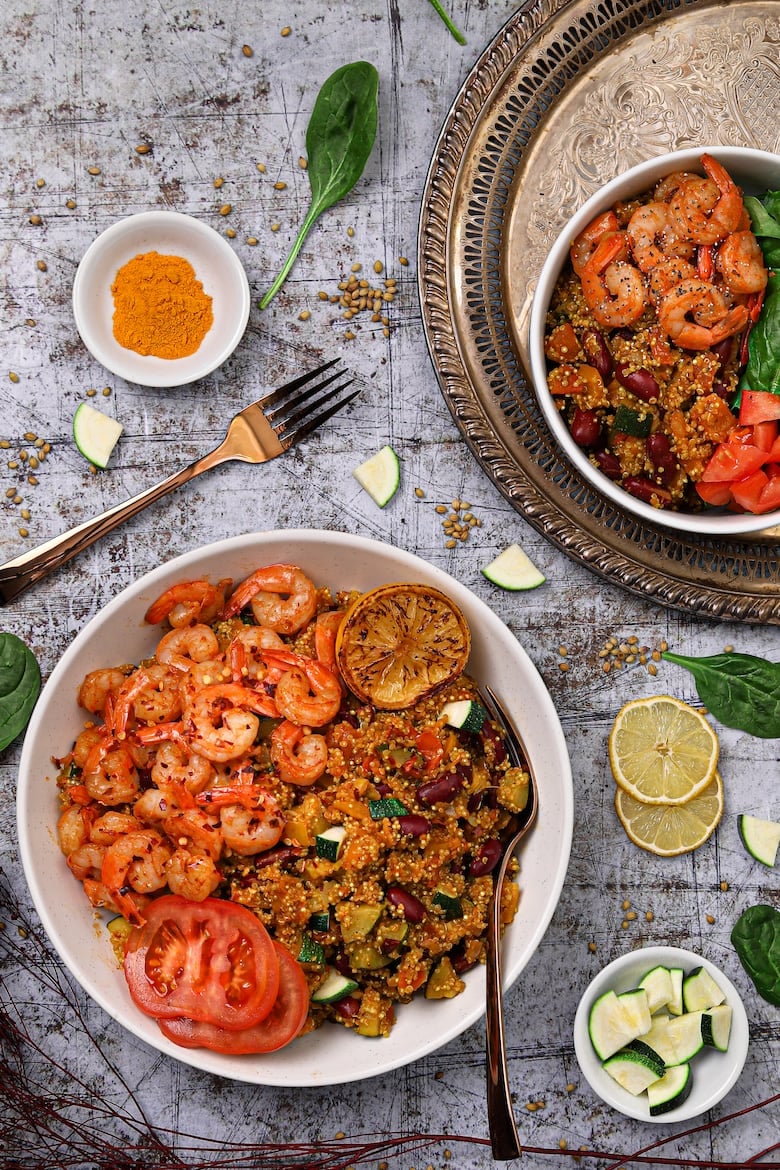 Bowl of vegetable quinoa with garlic shrimp recipe flat-lay