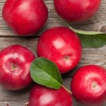 Ripe red apples on wooden table. Top view flat lay