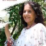 a woman standing next to a tree holding it's flowering branch - outdoors on Mother's Day 2020