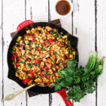 indian chaat salad with corn in a red staub pan with spoon in it