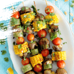 Tray of BBQ vegetable skewers on a bright blue background
