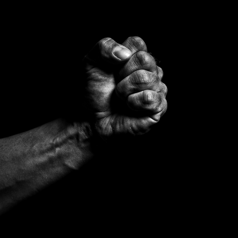 Fist of a Black person against a black background