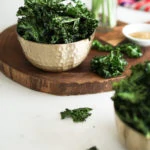 bowl of kale chips on a a wooden board