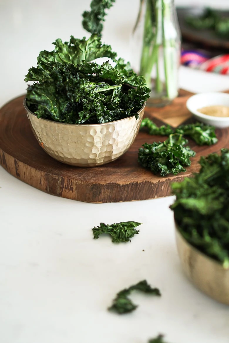 bowl of kale chips on a a wooden board
