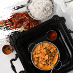 bowl of indian butter chicken on a black tray with white rice on the side flat lay
