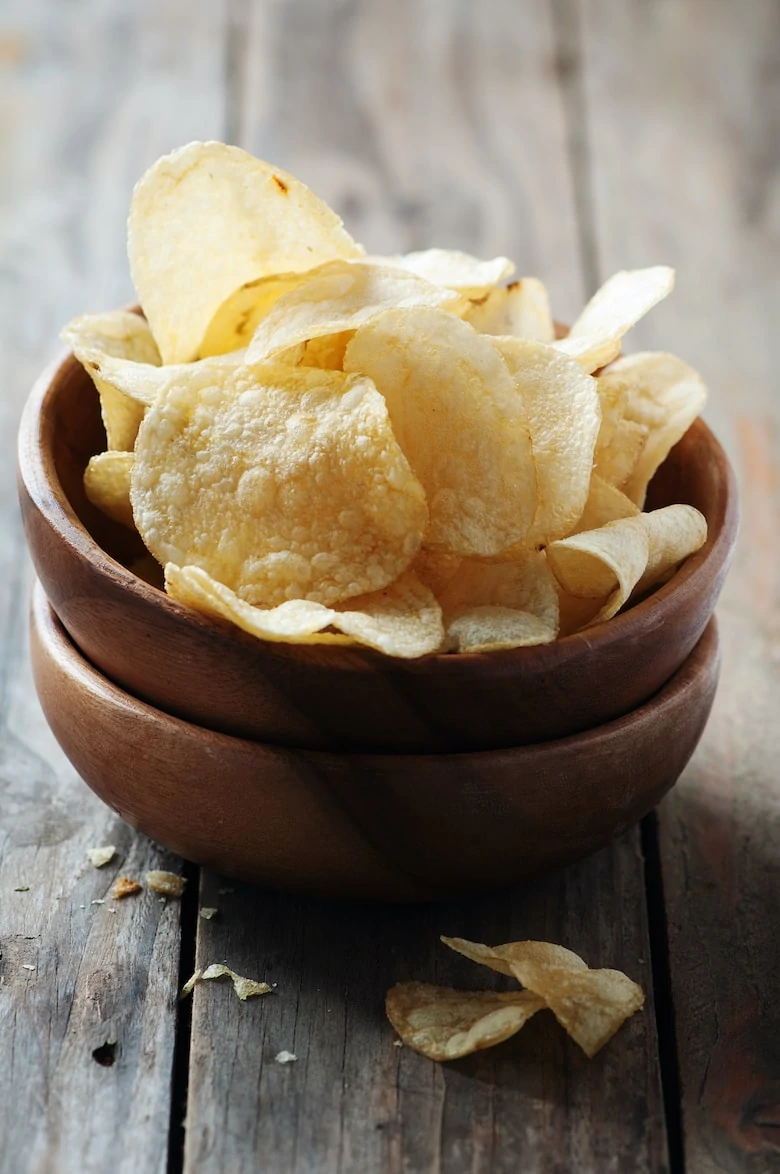 Potato chips on the wooden table, selective table