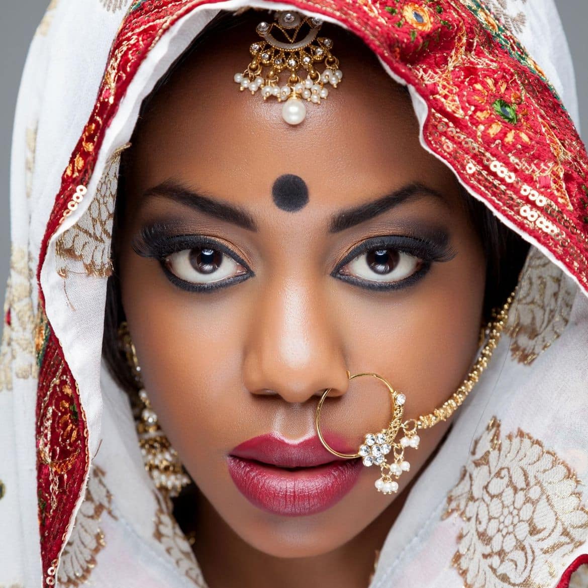 Young Indian woman in traditional clothing with bridal makeup an