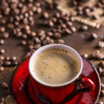 Coffee cup and coffee beans on rustic background