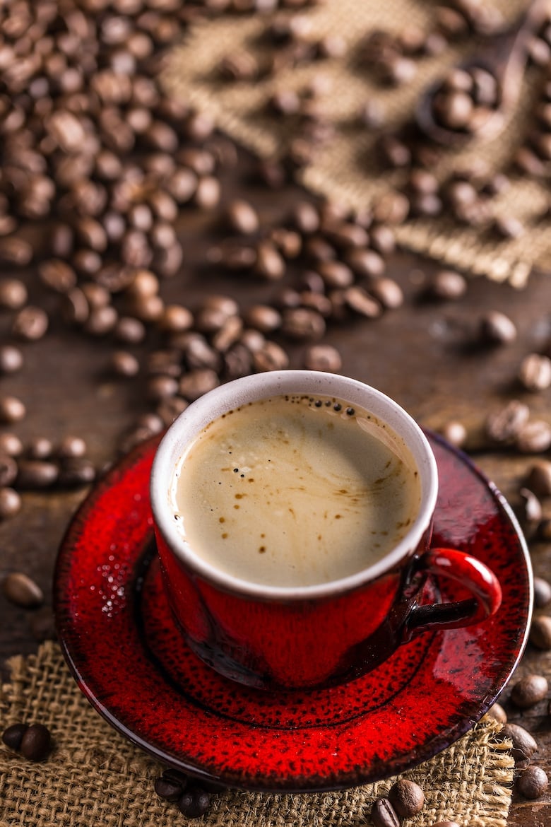 Coffee cup and coffee beans on rustic background