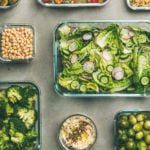 Healthy vegan dishes in containers. Flat-lay of vegetable salads, legumes, beans, olives, sprouts, hummus dip, couscous for take-away lunch, top view. Spring menu, clean eating, dieting food concept
