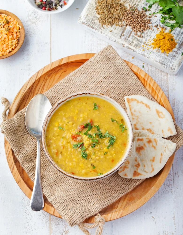 Lentil soup with bread in a ceramic white bowl on a wooden background Top view