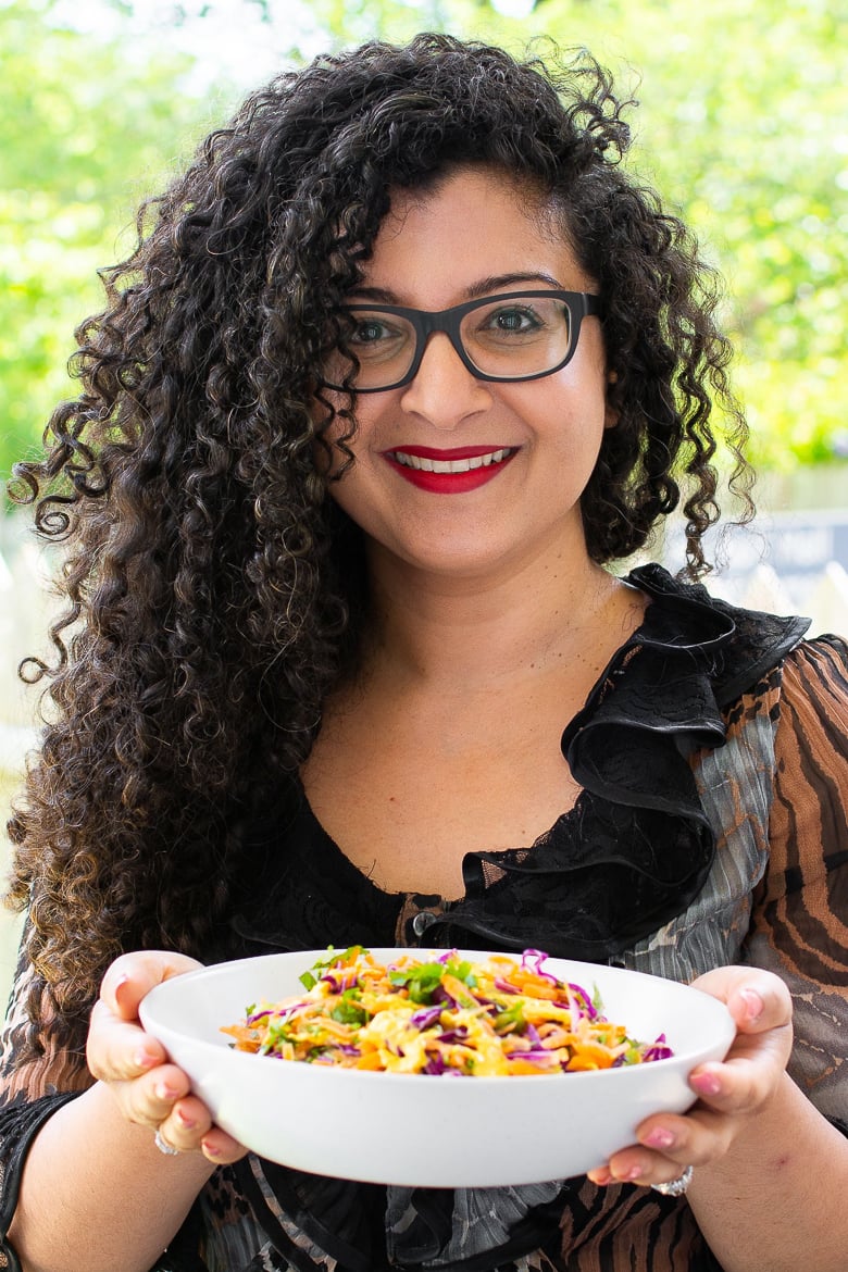 Desi~licious RD, Shahzadi, with long beautiful hair holding a bowl of salad and smiling