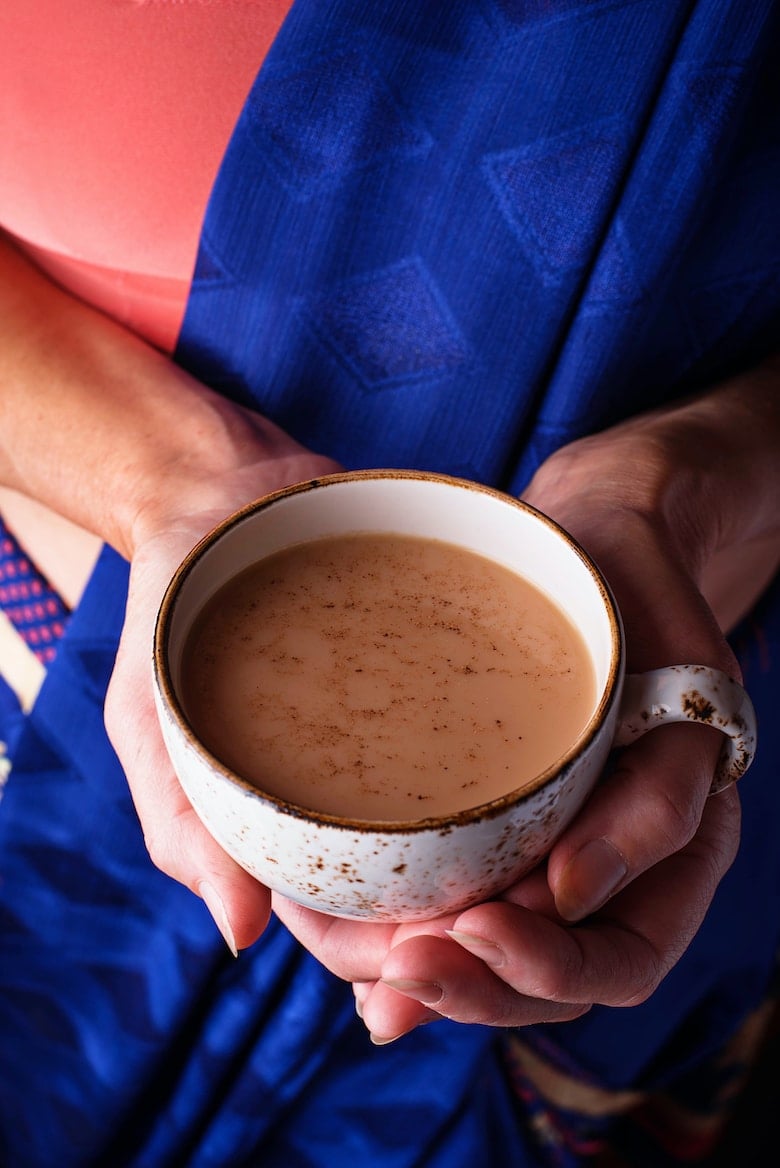 Woman in sari holding a cup of masala chai tea