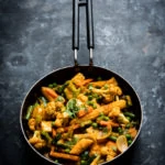 pan of Indian vegetable curry on a grey backdrop