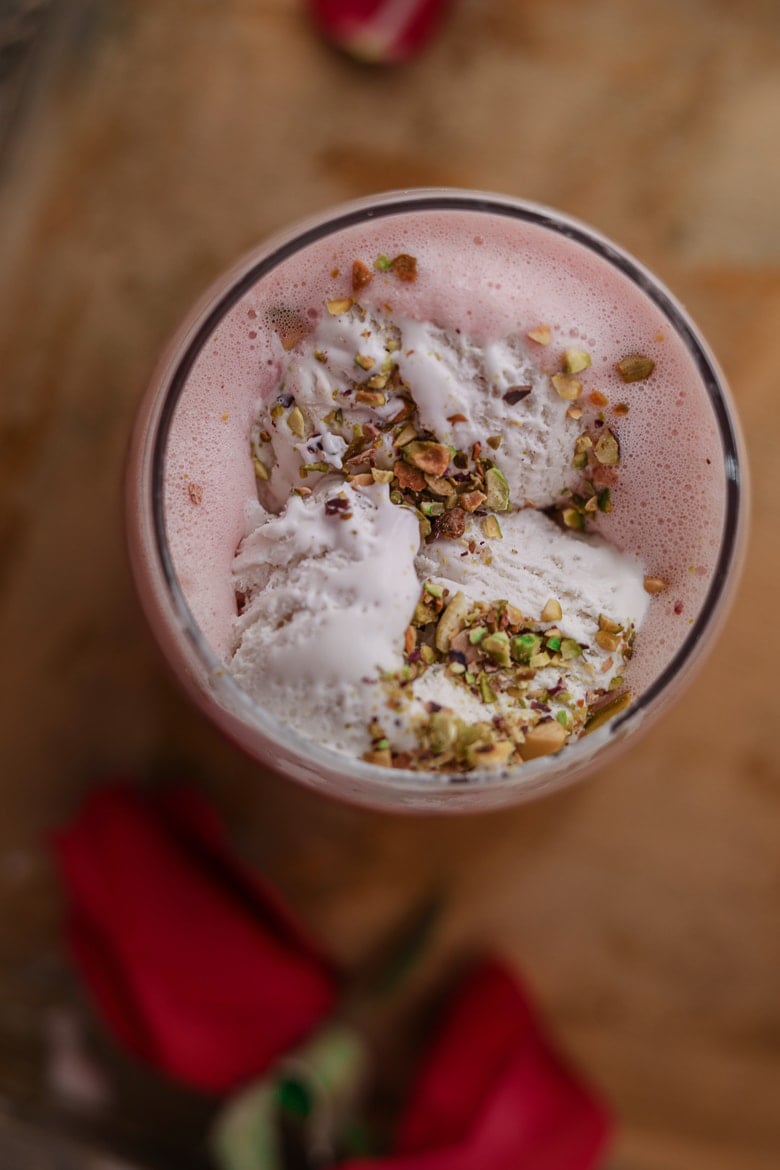 birds eye view of falooda topped wth white ice cream and crushed pistachios
