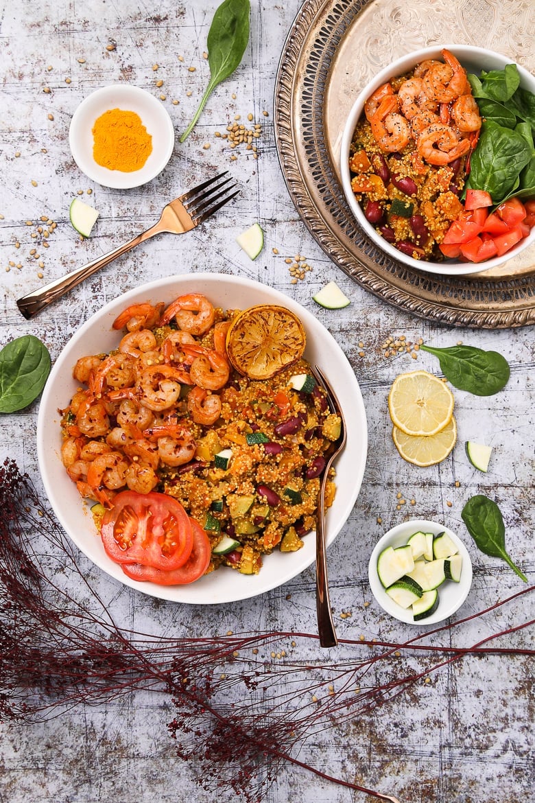 Bowl of vegetable quinoa with garlic shrimp recipe flat-lay