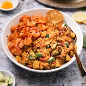 Bowl of vegetable quinoa with garlic shrimp recipe flat-lay close up