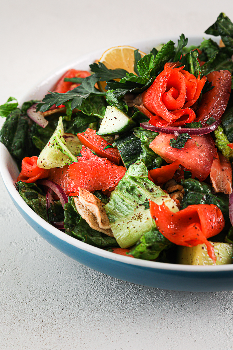 close up shot of bowl of fattoush salad with smoked salmon