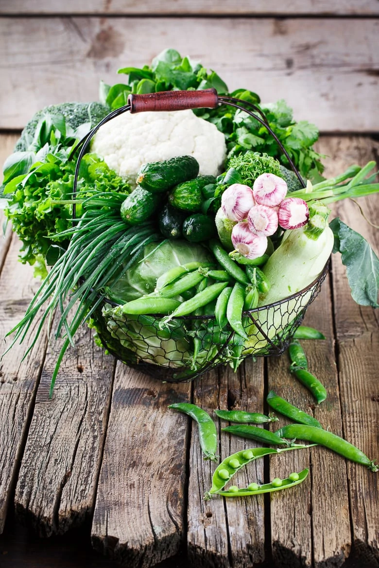 Vegetables variety in a wire basket on a wooden background. selective focus