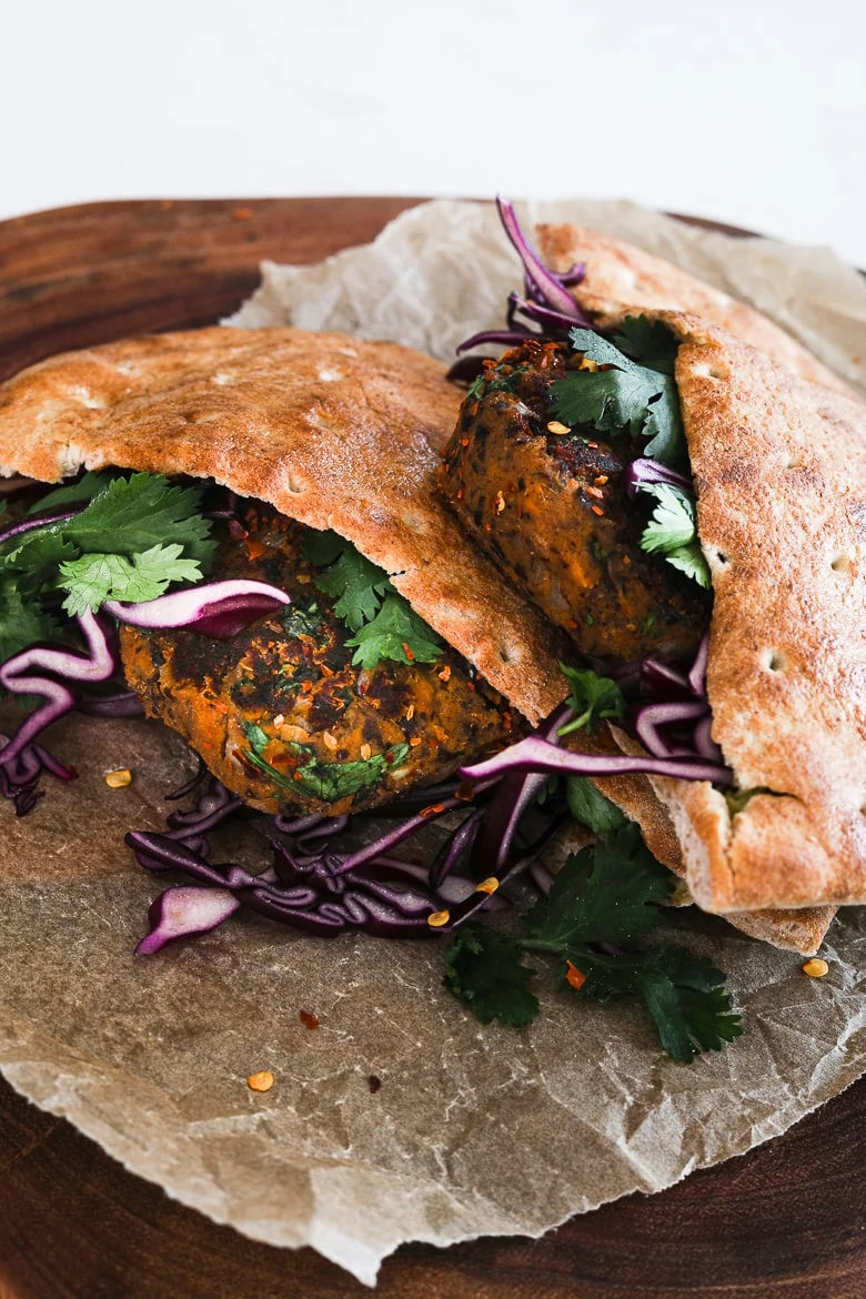 two pita breads stuffed with vegan kebab, purple cabbage and cilantro leaves