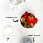 labelled ingredients of what's needed to make strawberry lassi drink