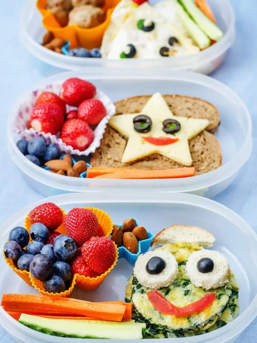 School lunch boxes for kids with food in the form of funny faces. the toning. selective focus