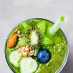 Glass of green healthy smoothie decorate with ingredients, top view, copy space