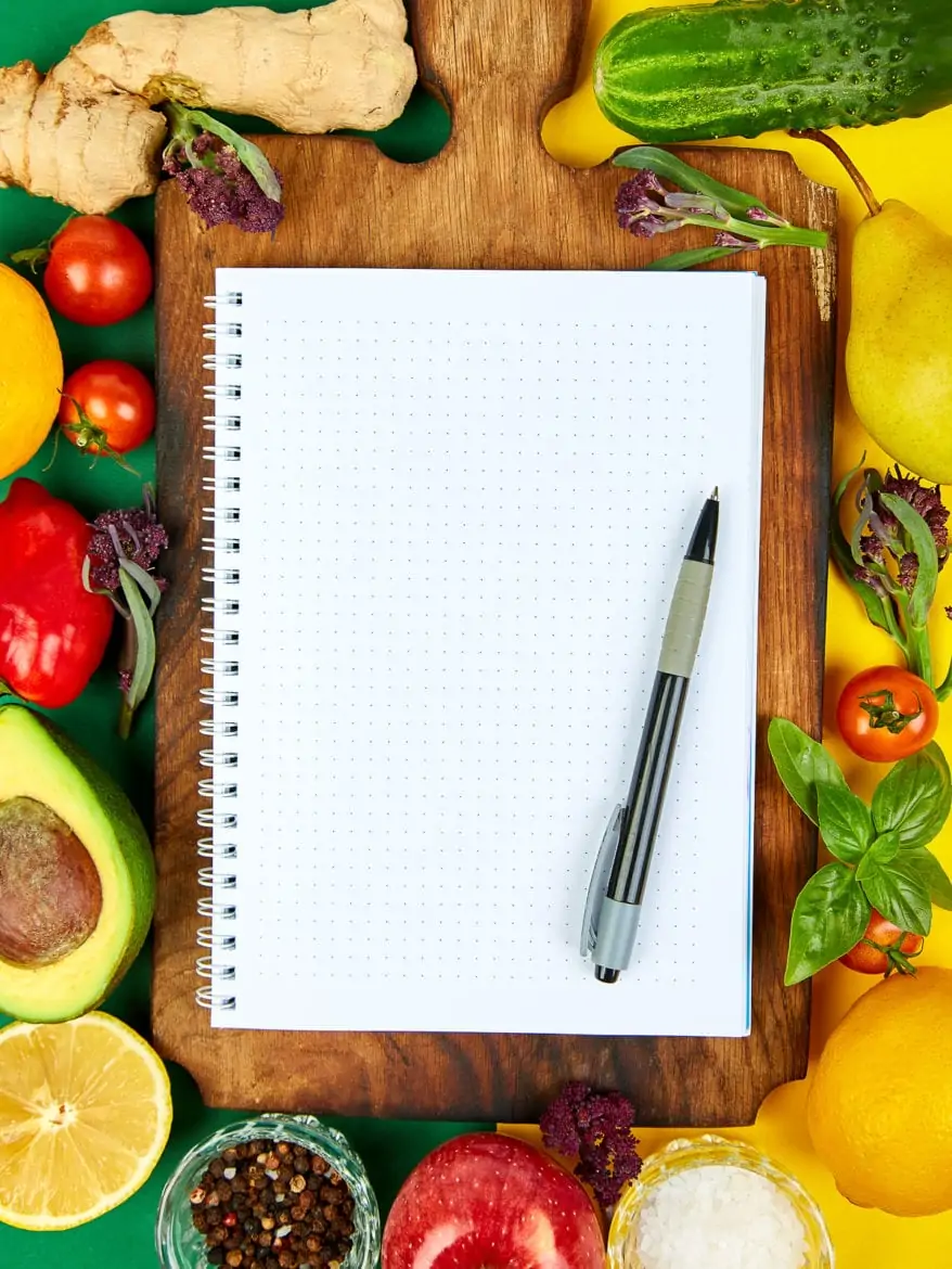 Shopping list, recipe book, diet plan. Fresh raw vegetables, fruit and ingredients for healthy cooking. top view, place for text. Diet or vegan food, vegetarian and healthily cooking concept. Flat lay. Notepad for your recipe concept.