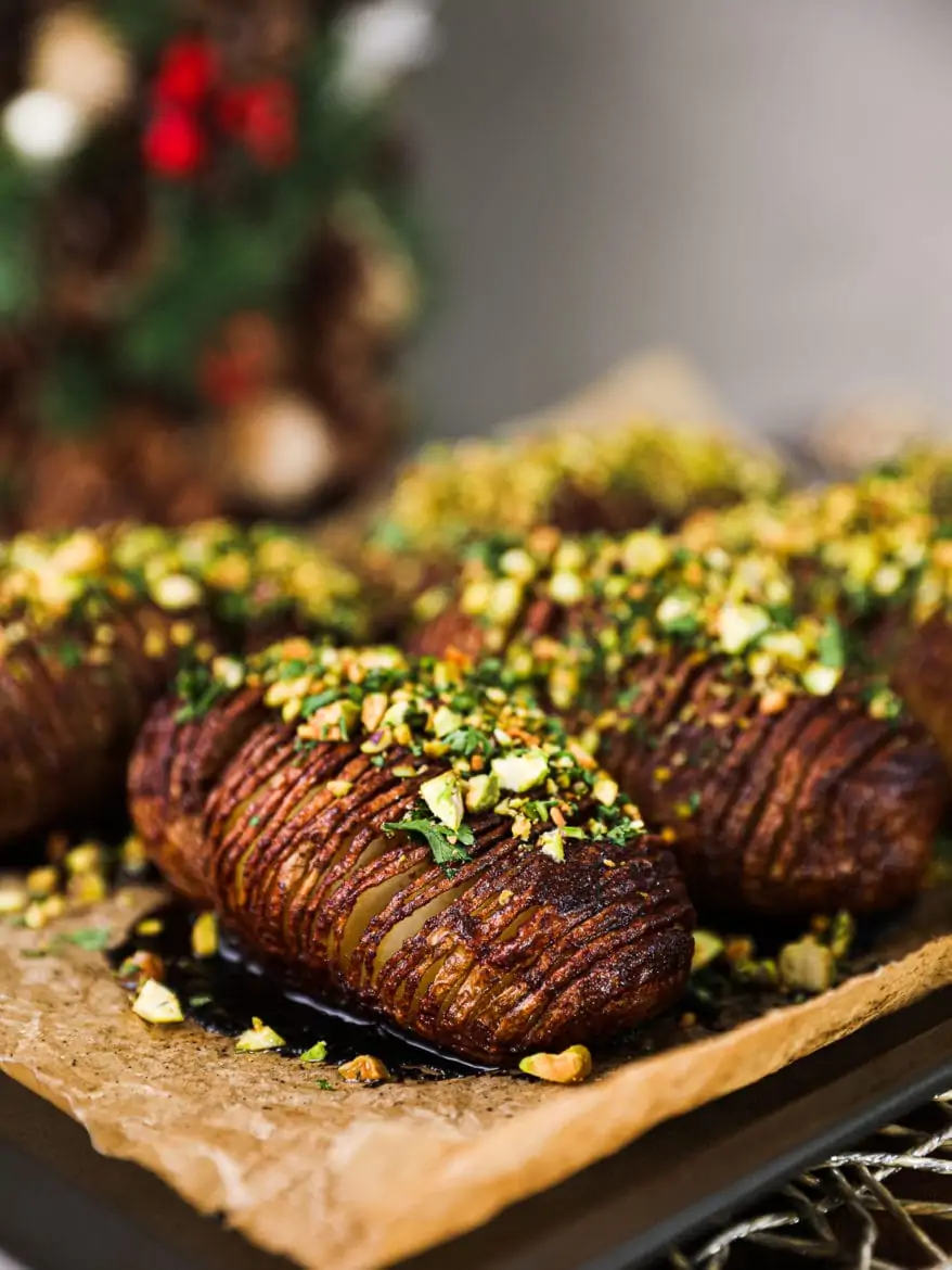 hasselback potatoes dressed with maple and pistachio-herb crust - close up shot