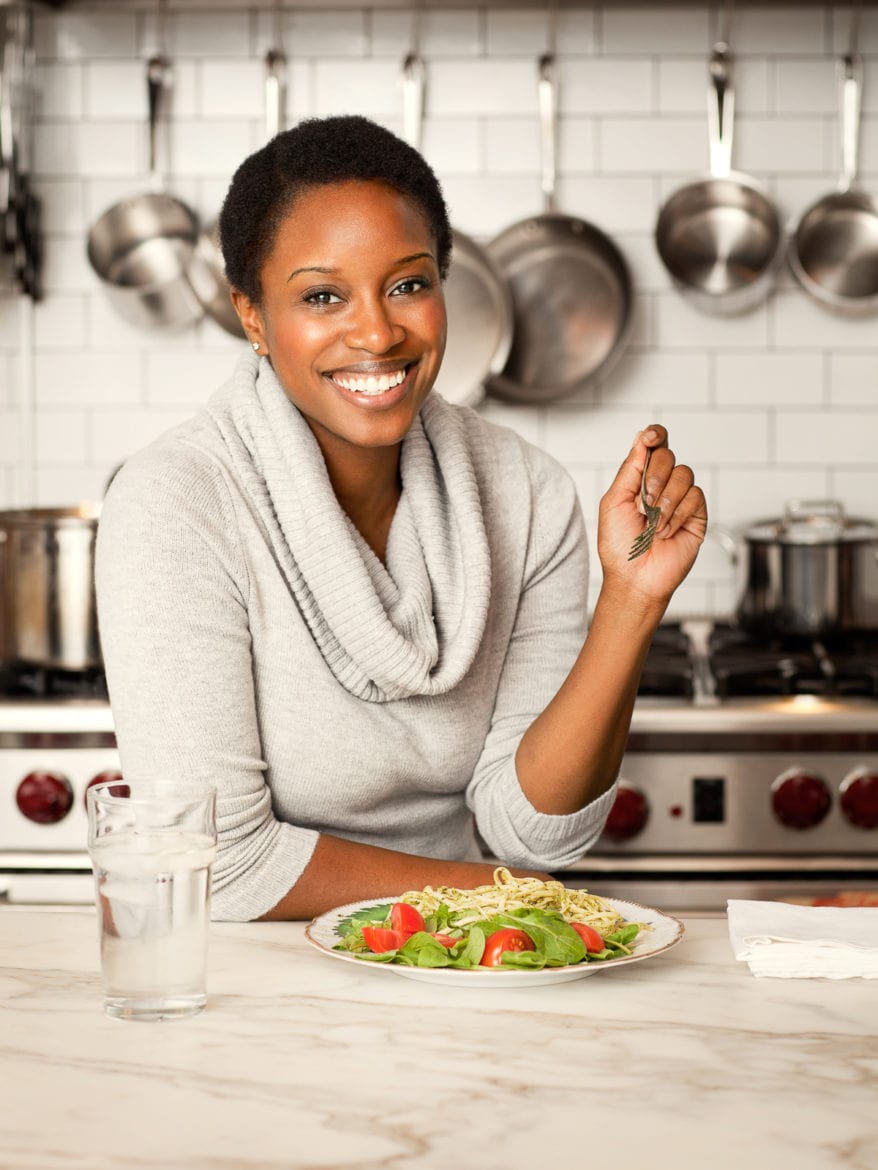 Portrait Of Woman Eating Pasta At Kitchen Island