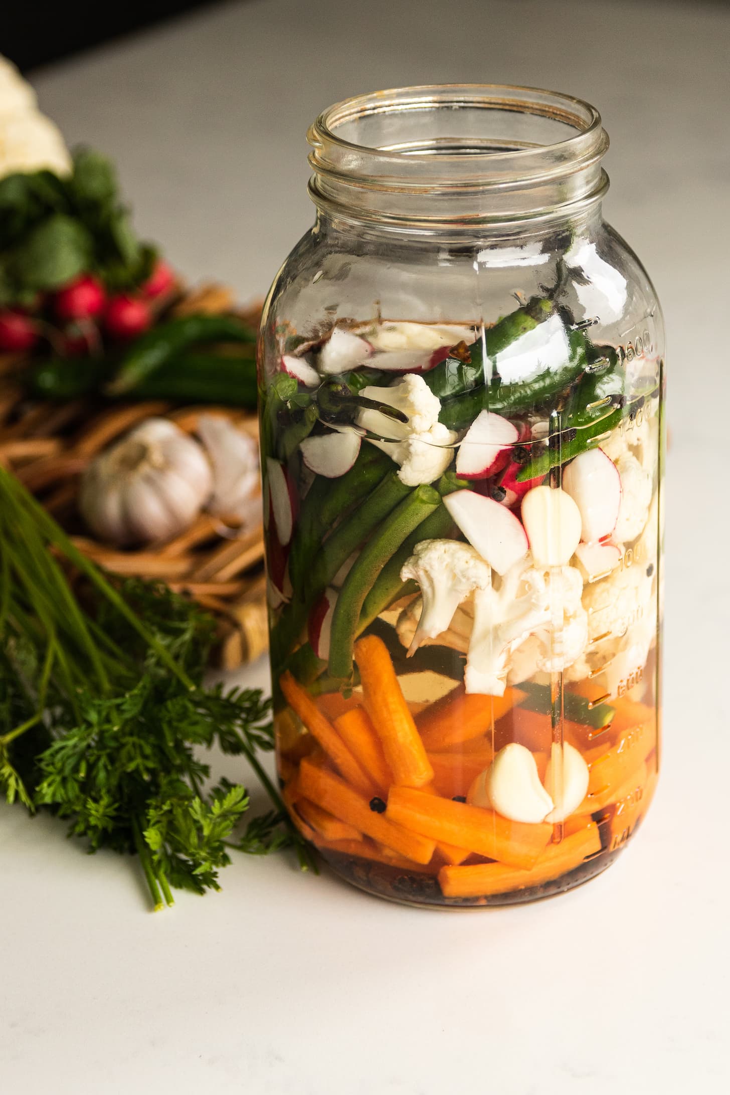 a jar filled with water and chopped mixed vegetables.