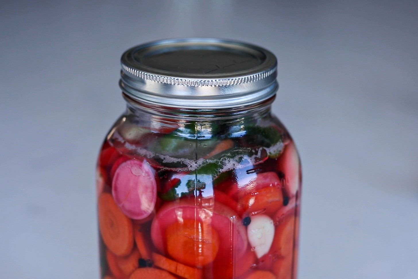 mason jar filled with water and mixed chopped vegetables.