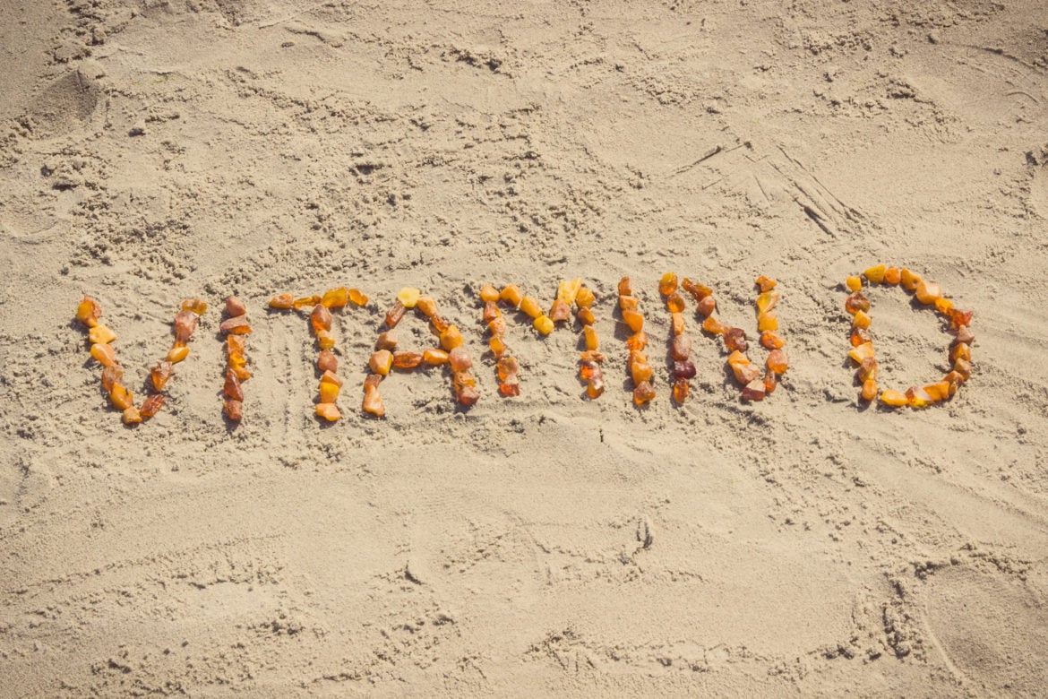 Inscription vitamin D on sand at beach