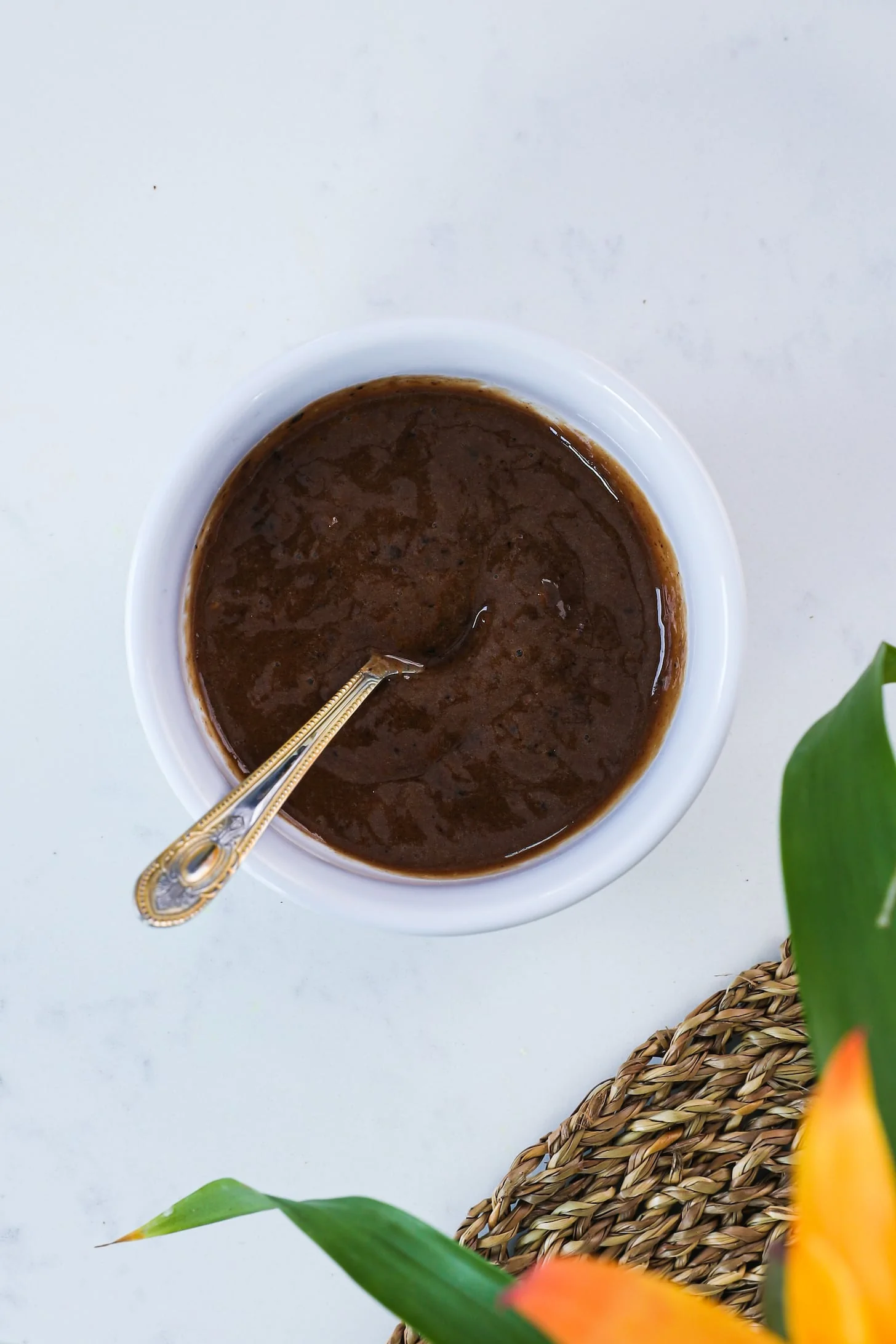 a spoon dipped into a bowl of tamarind chutney (sauce).