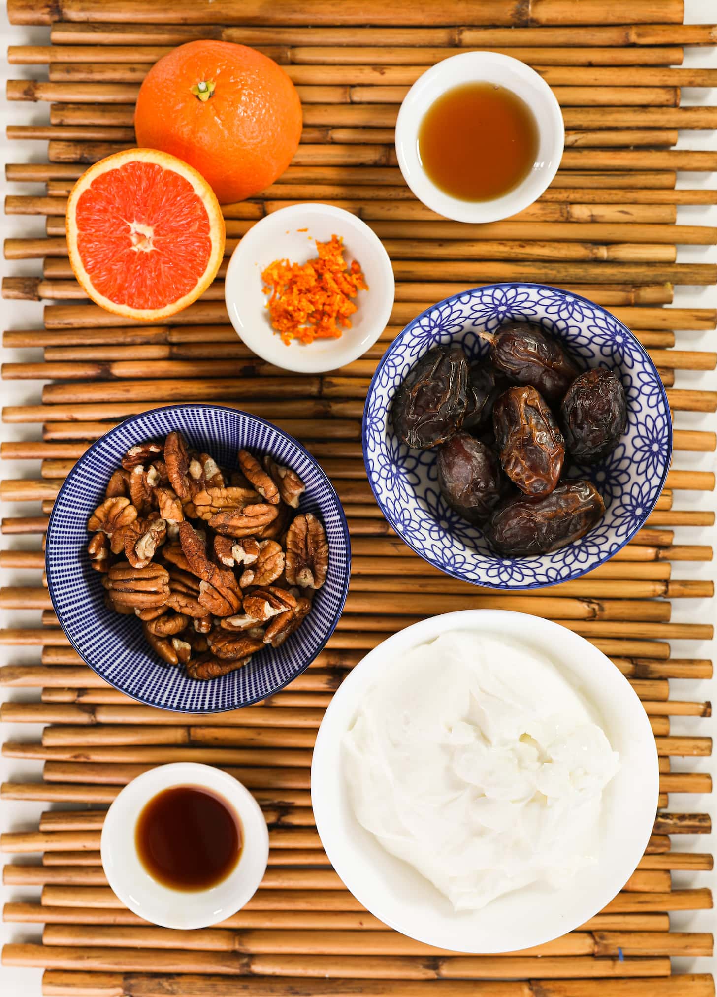 ramekins of ingredients filled with dates, pecans, yogurt, brown liquids and orange zest.