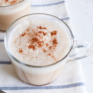 cup of white liquid with froth and brown spice on top.