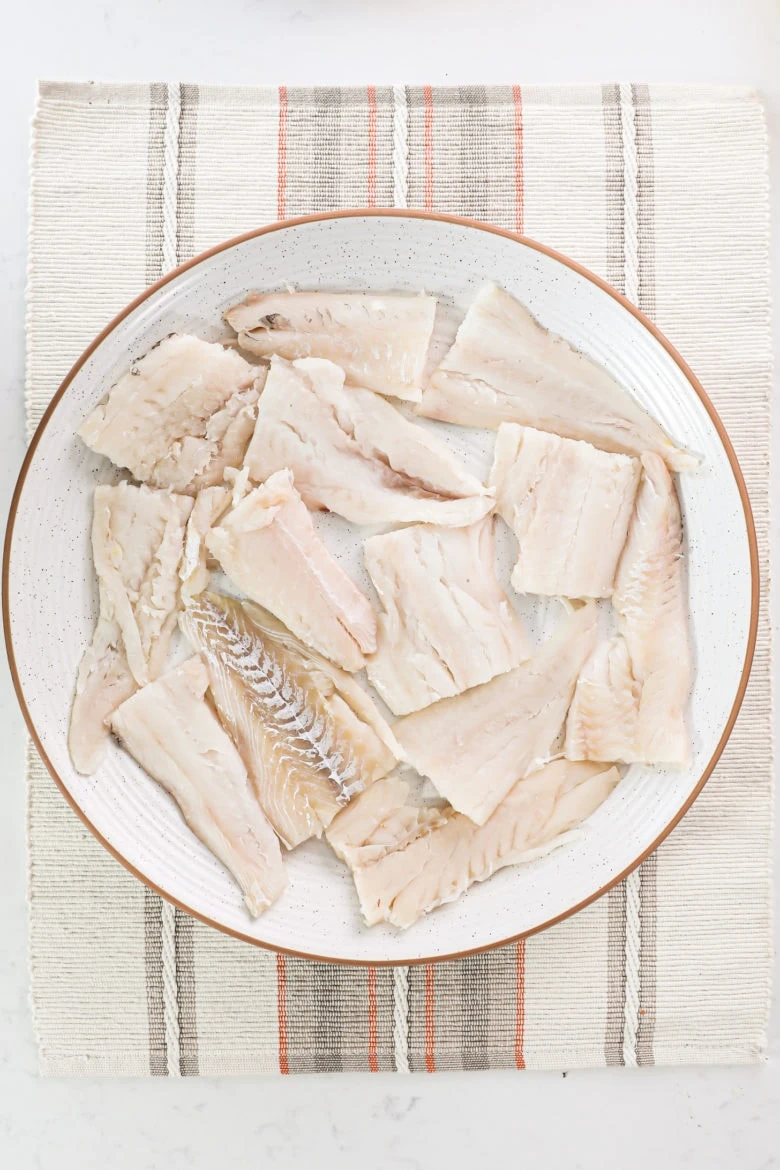 a plate of fish fillets arranged in a single layer.