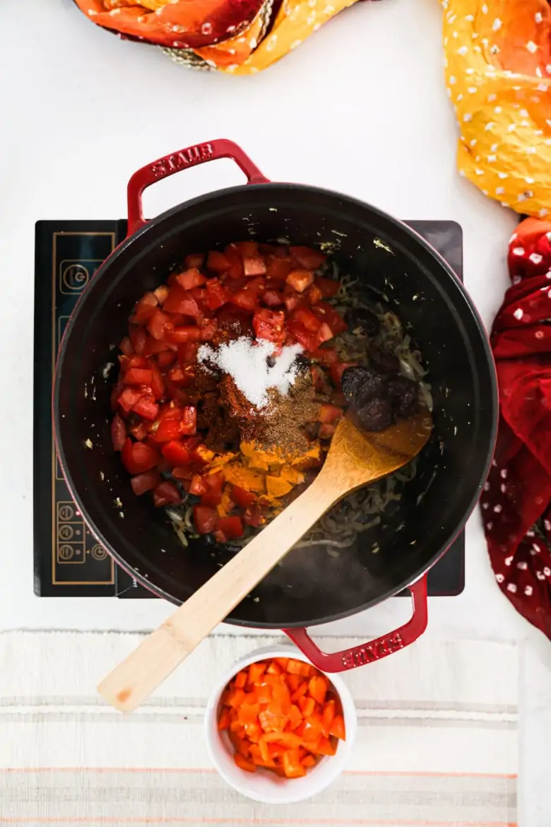 a large pot with chopped tomatoes, spices and salt.